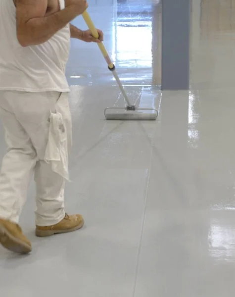 Aplicação de tinta epóxi com rolo em piso residencial de concreto — processo de revitalização com acabamento uniforme