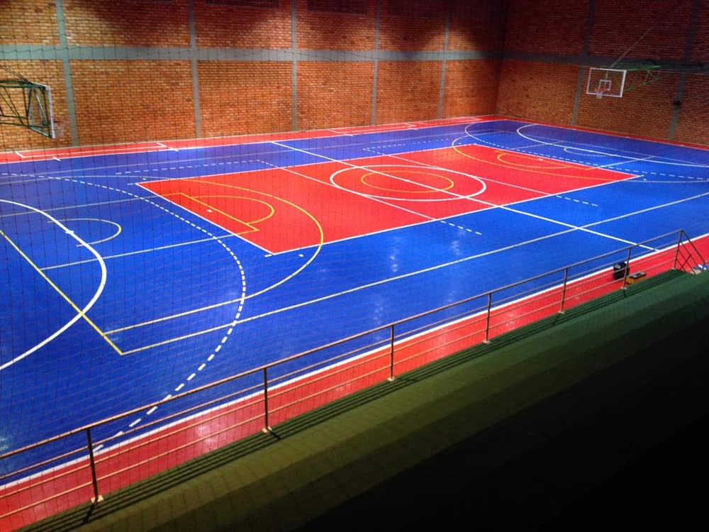 Quadra poliesportiva com piso epóxi verde e linhas de demarcação brancas — acabamento brilhante e cores vivas